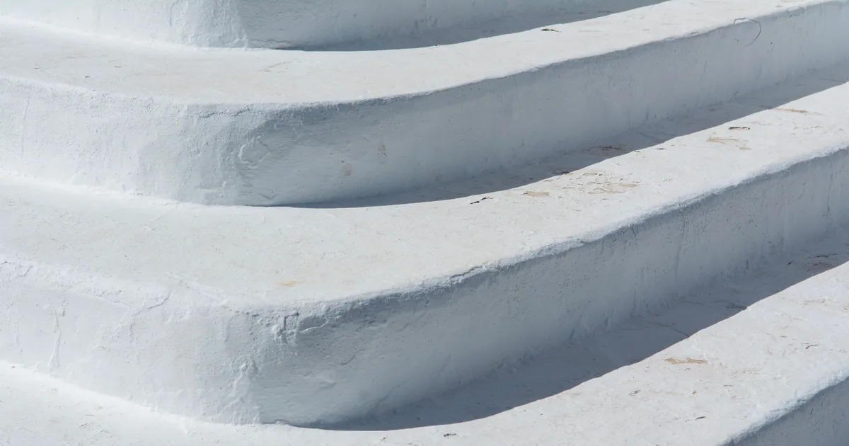 Concrete surface showing dark patches after pressure washing