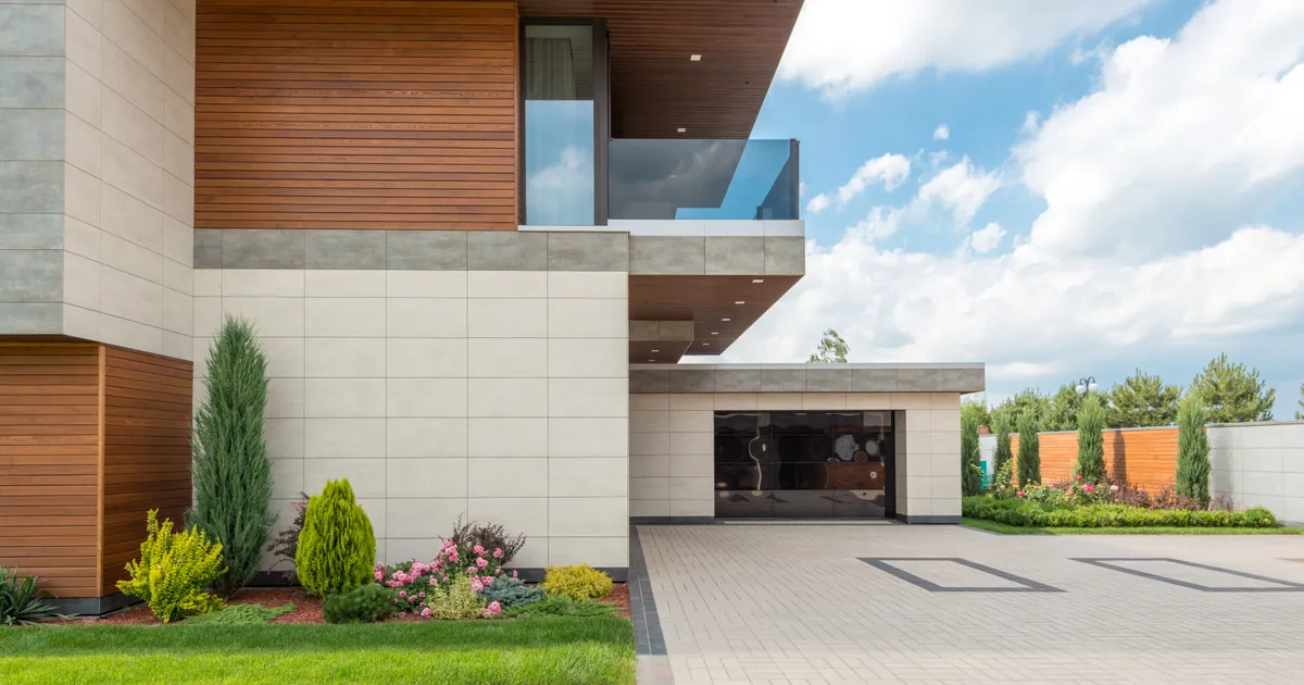 Wide concrete driveway in front of a modern house before pressure washing
