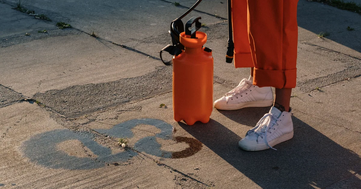 Applying a soft wash cleaning solution to a hard surface with a low pressure sprayer